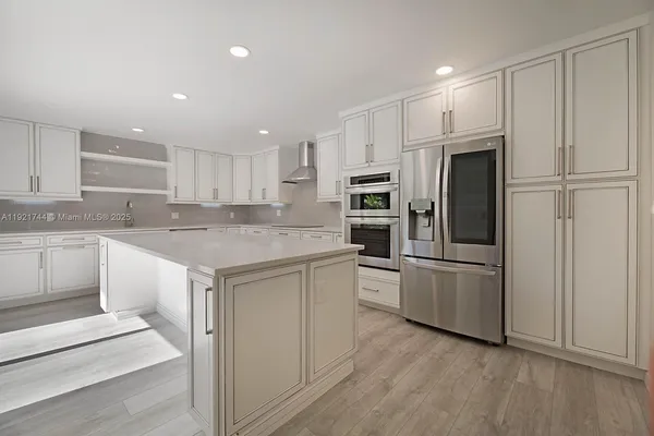 a kitchen with white cabinets and stainless steel appliances