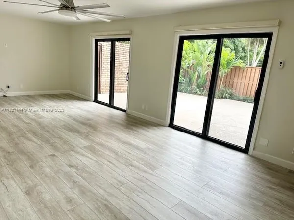 an empty room with wooden floor and sliding door