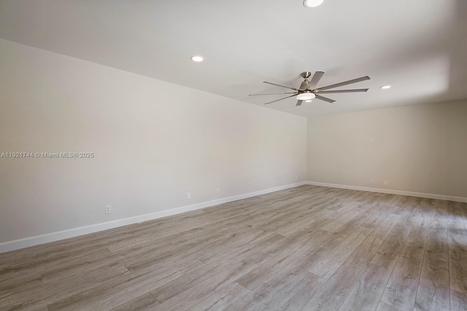 1420 Ocean Way, Unit 19D Jupiter, FL 33477 - Photo 13 of 34 a view of a room with wooden floor and a ceiling fan