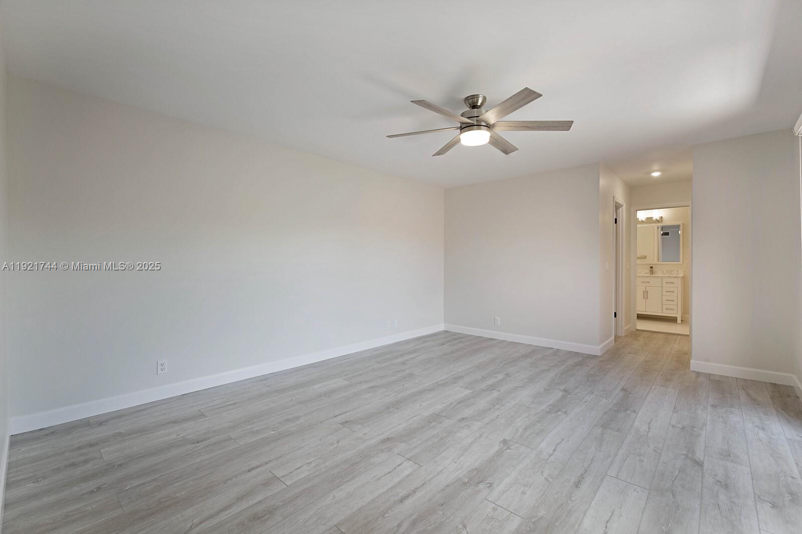 1420 Ocean Way, Unit 19D Jupiter, FL 33477 - Photo 19 of 34 a view of an empty room with wooden floor and a ceiling fan