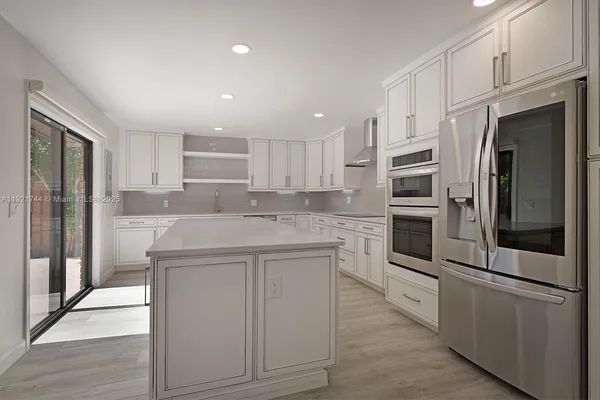 a kitchen with stainless steel appliances a refrigerator sink and microwave