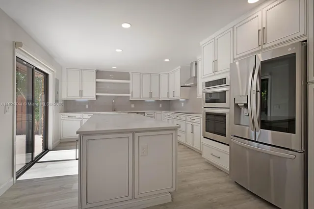 a kitchen with stainless steel appliances a refrigerator sink and microwave