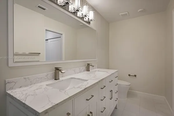 a bathroom with a sink vanity granite and a mirror