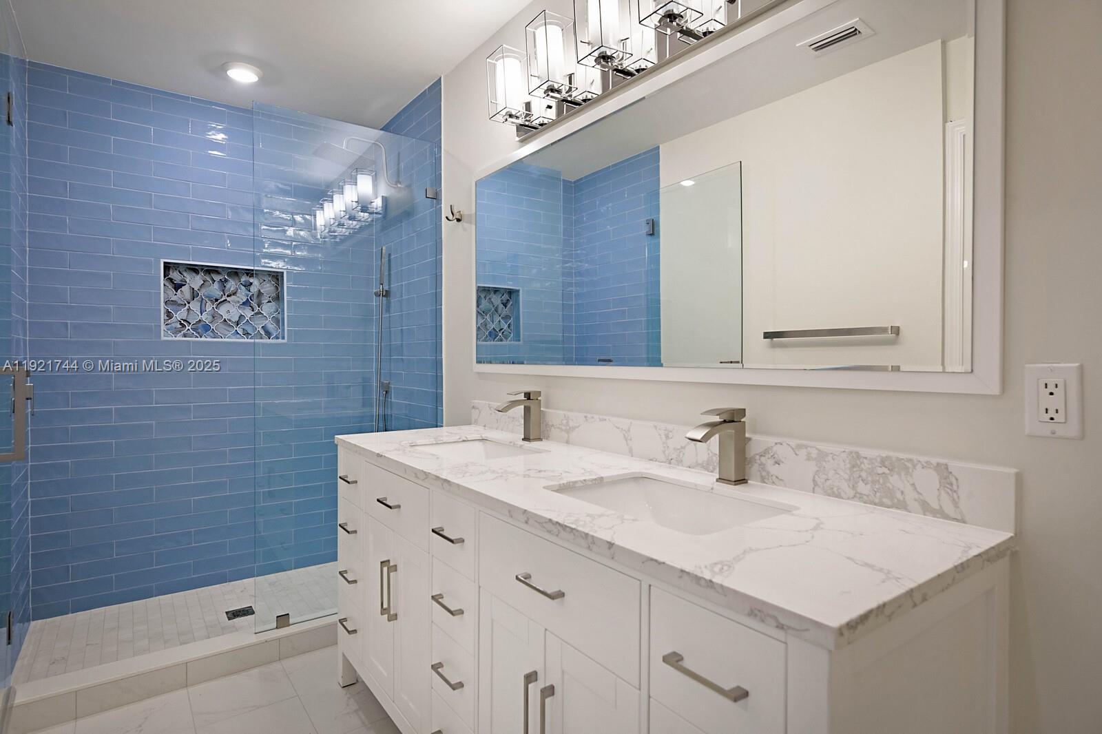 1420 Ocean Way, Unit 19D Jupiter, FL 33477 - Photo 23 of 34 a bathroom with a sink a vanity a mirror and a bathtub