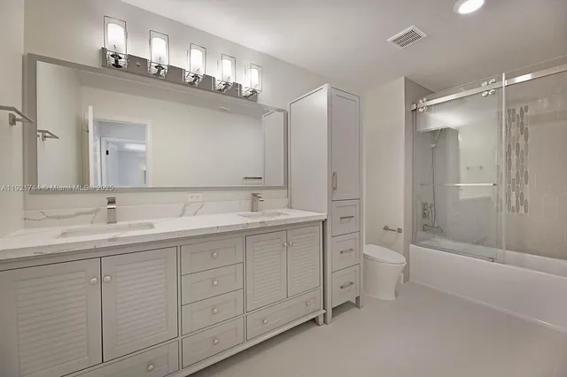 a bathroom with a double vanity sink mirror and toilet