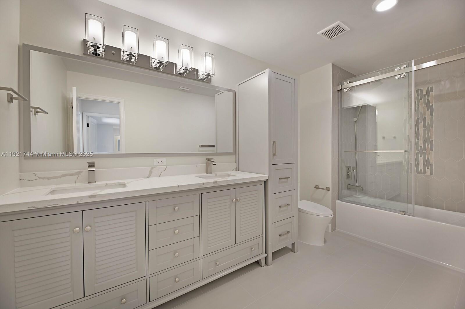 1420 Ocean Way, Unit 19D Jupiter, FL 33477 - Photo 30 of 34 a bathroom with a double vanity sink mirror and toilet