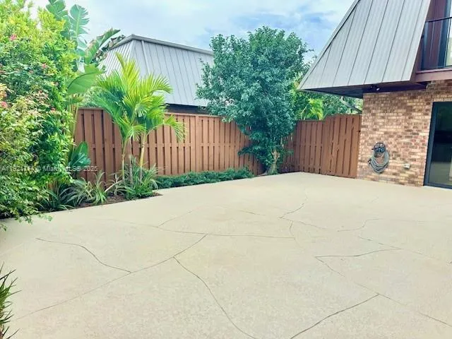 a view of backyard and wooden fence