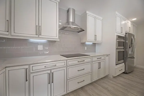 a kitchen with granite countertop white cabinets and stainless steel appliances