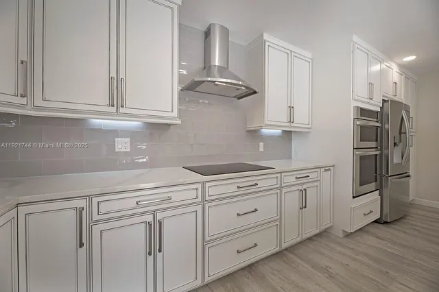 a kitchen with granite countertop white cabinets and stainless steel appliances