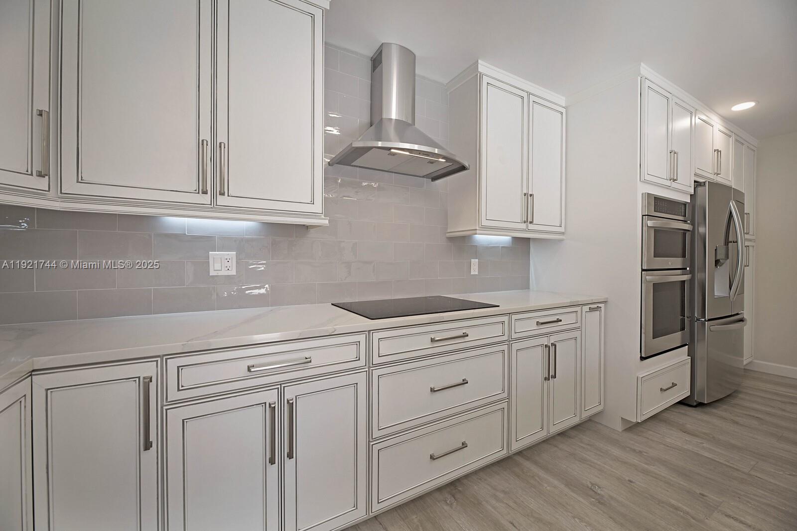 1420 Ocean Way, Unit 19D Jupiter, FL 33477 - Photo 6 of 34 a kitchen with granite countertop white cabinets and stainless steel appliances