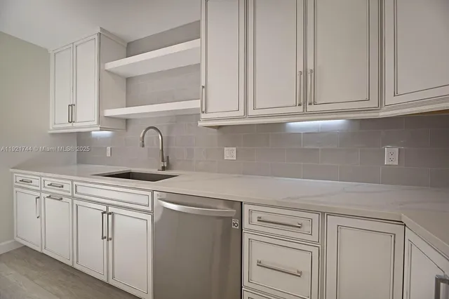 a kitchen with white cabinets and a sink