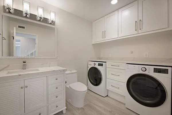 a view of a bathroom with washing machine and a sink