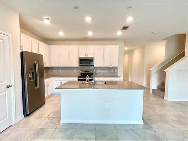 a kitchen with a stove a sink and a refrigerator