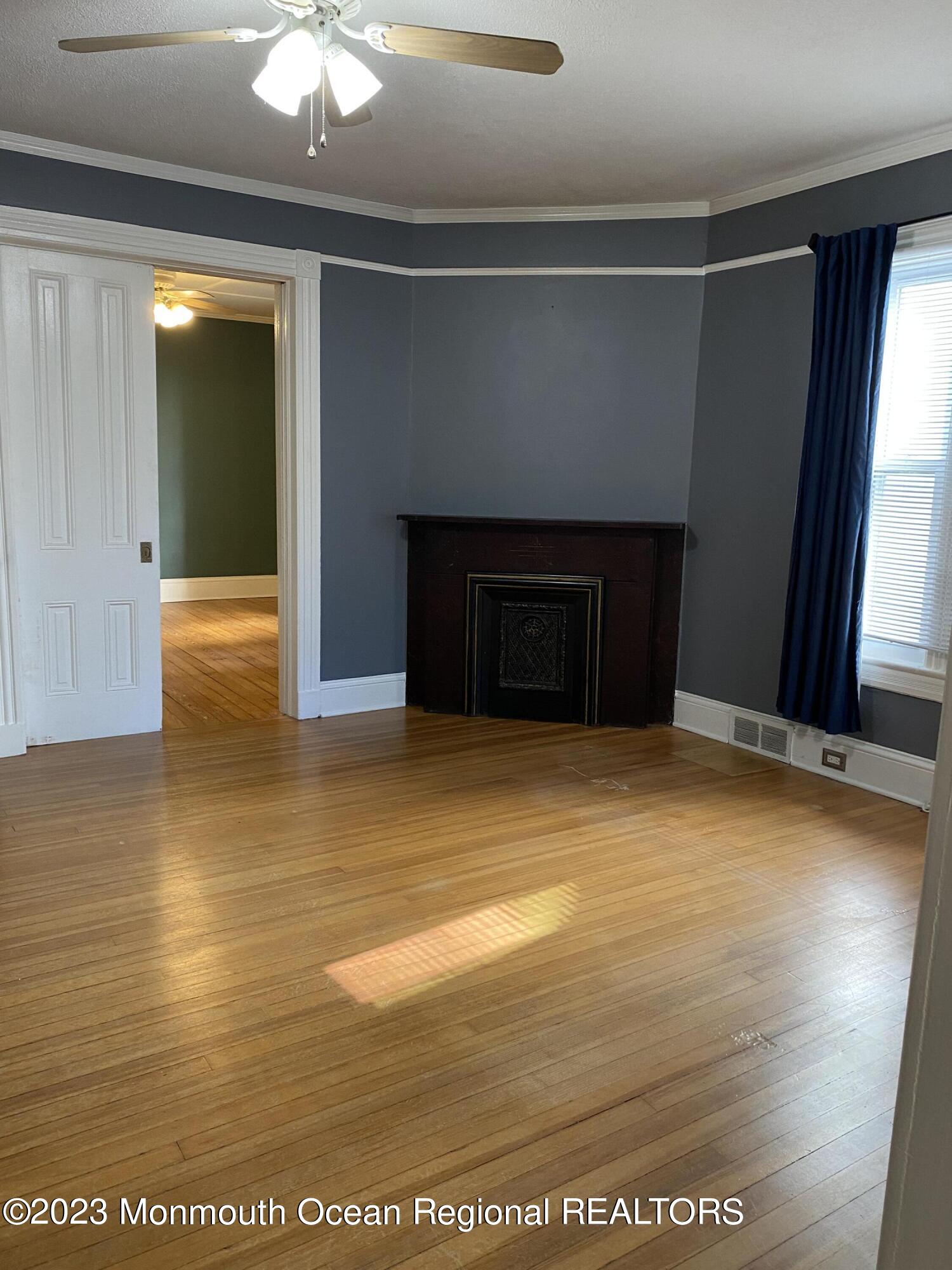 24-26 Rector Place Red Bank, NJ 07701 - Photo 4 of 6 a view of an empty room with wooden floor and a window