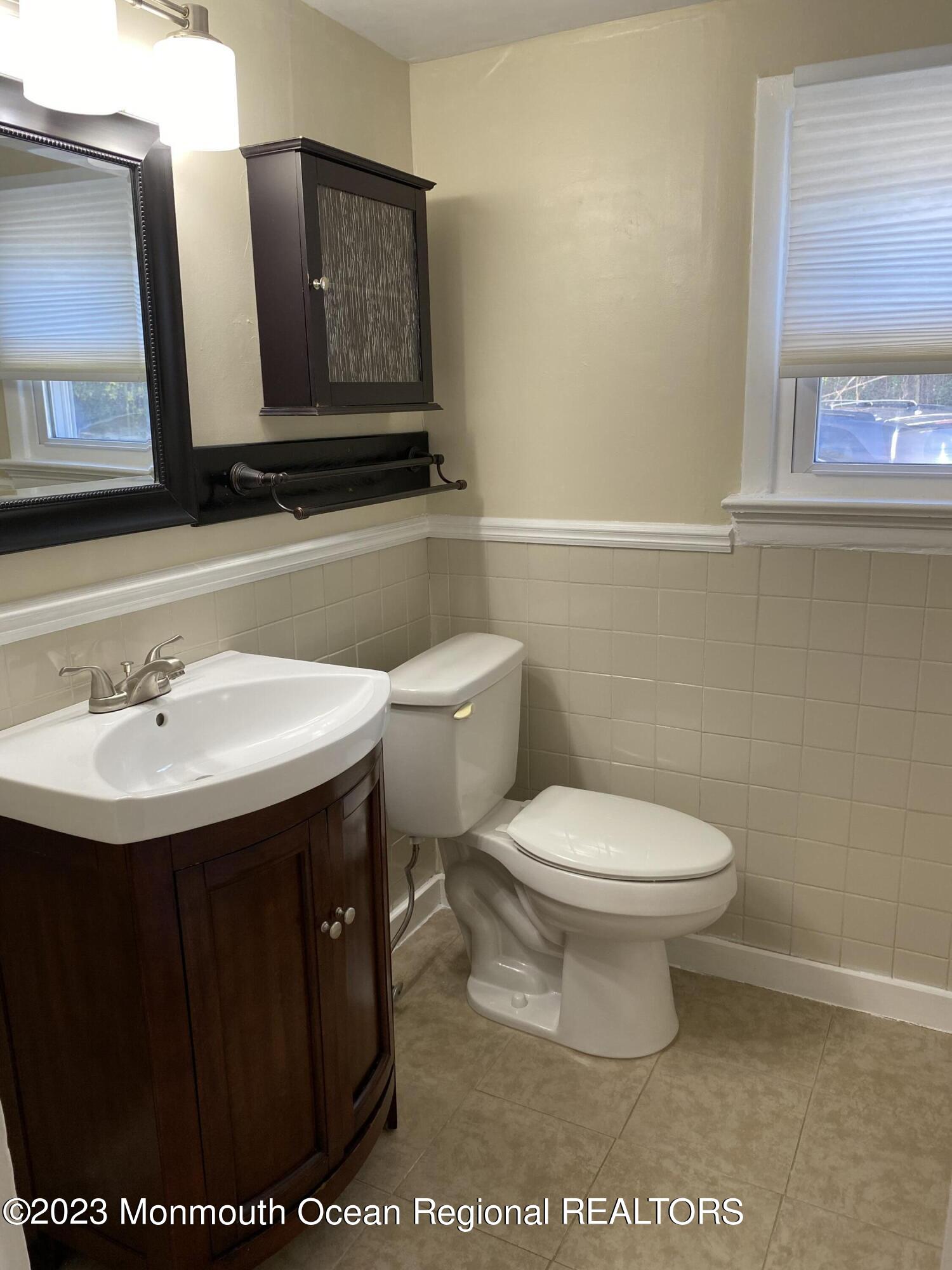 24-26 Rector Place Red Bank, NJ 07701 - Photo 5 of 6 a bathroom with a toilet sink and mirror