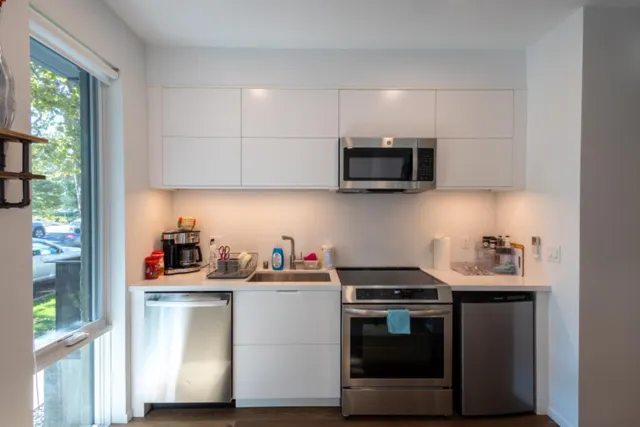 a kitchen with stainless steel appliances granite countertop a refrigerator sink and stove