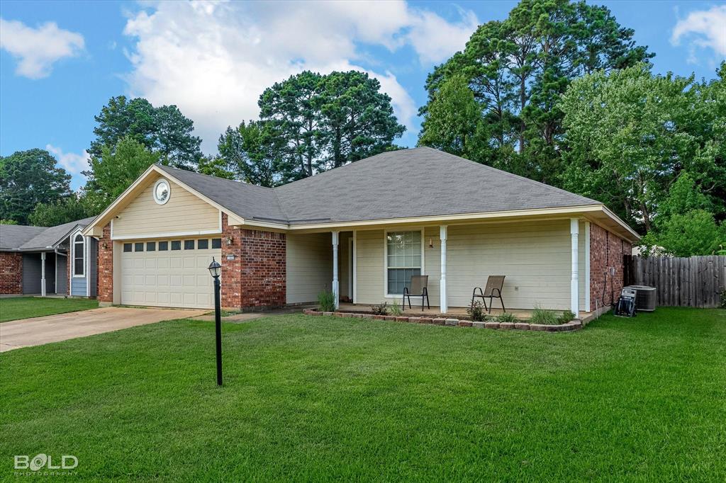 122 Ragan Lane Haughton, LA 71037 - Photo 27 of 34 Brick and siding exterior with an attached garage, covered front porch, and a gravel driveway