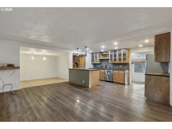 a view of kitchen with kitchen island granite countertop a stove top oven and a sink with granite countertops