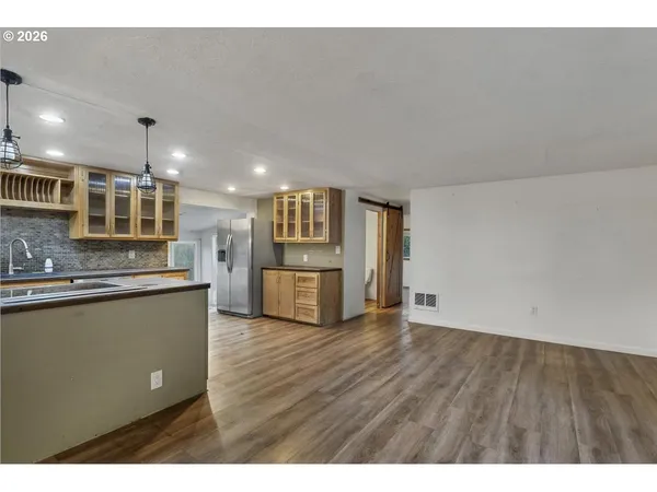 a view of kitchen with stainless steel appliances granite countertop cabinets and wooden floor