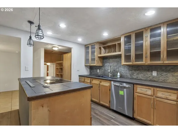 a kitchen with kitchen island granite countertop a sink cabinets and stainless steel appliances