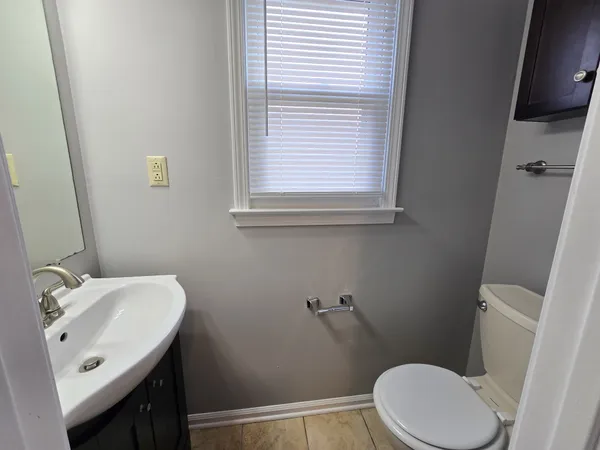 a bathroom with a sink a toilet and a mirror