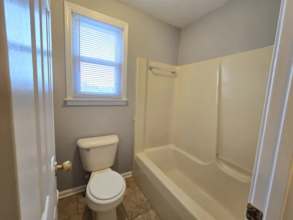a white toilet sitting next to a bath tub