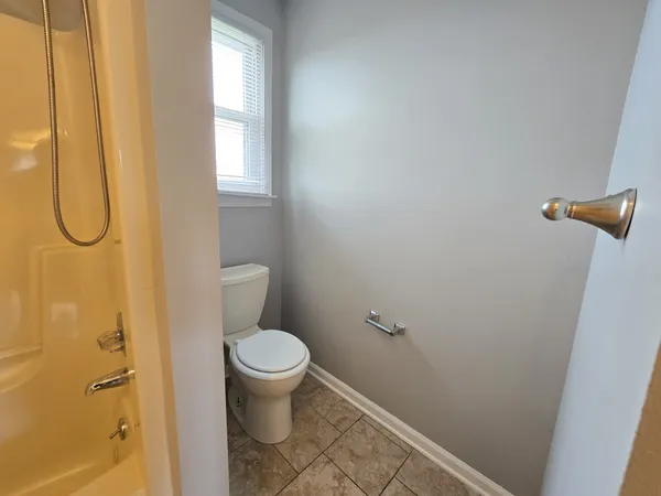 a bathroom with a granite countertop sink and a toilet