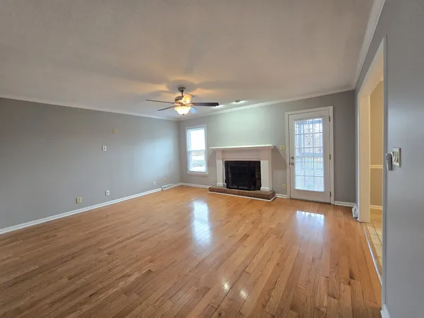 a view of empty room with wooden floor and fireplace