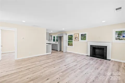 a view of empty room with wooden floor and fireplace