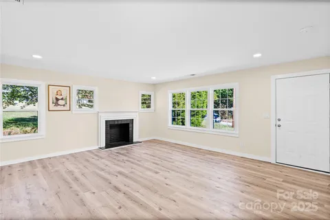 an empty room with windows and a fireplace