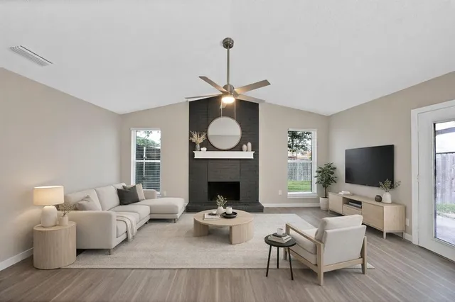 a living room with furniture a fireplace and a flat screen tv