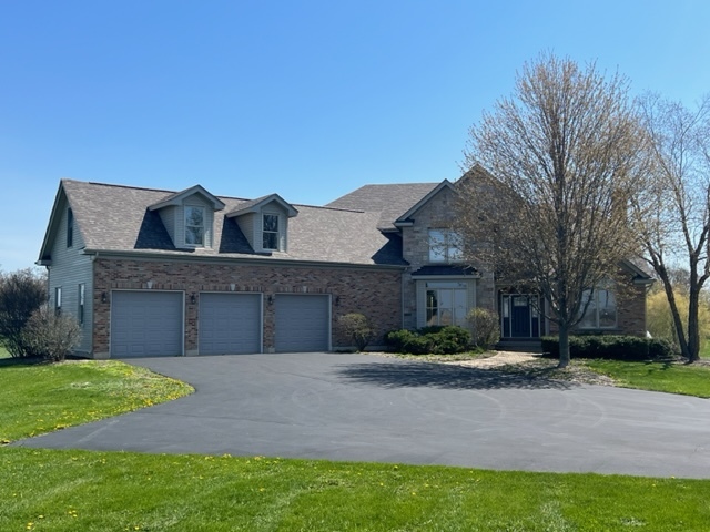 10902 Zarnstorff Road Richmond, IL 60071 - Photo 1 of 14 a front view of a house with a yard and garage