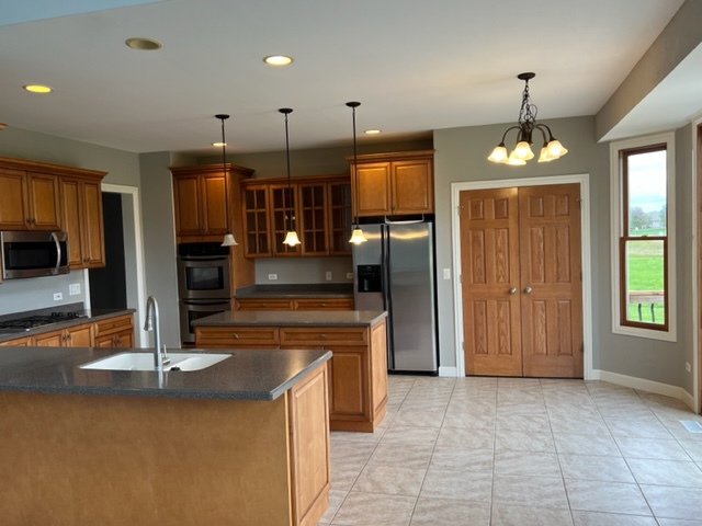 10902 Zarnstorff Road Richmond, IL 60071 - Photo 3 of 14 a view of a kitchen with kitchen island granite countertop a refrigerator and a sink