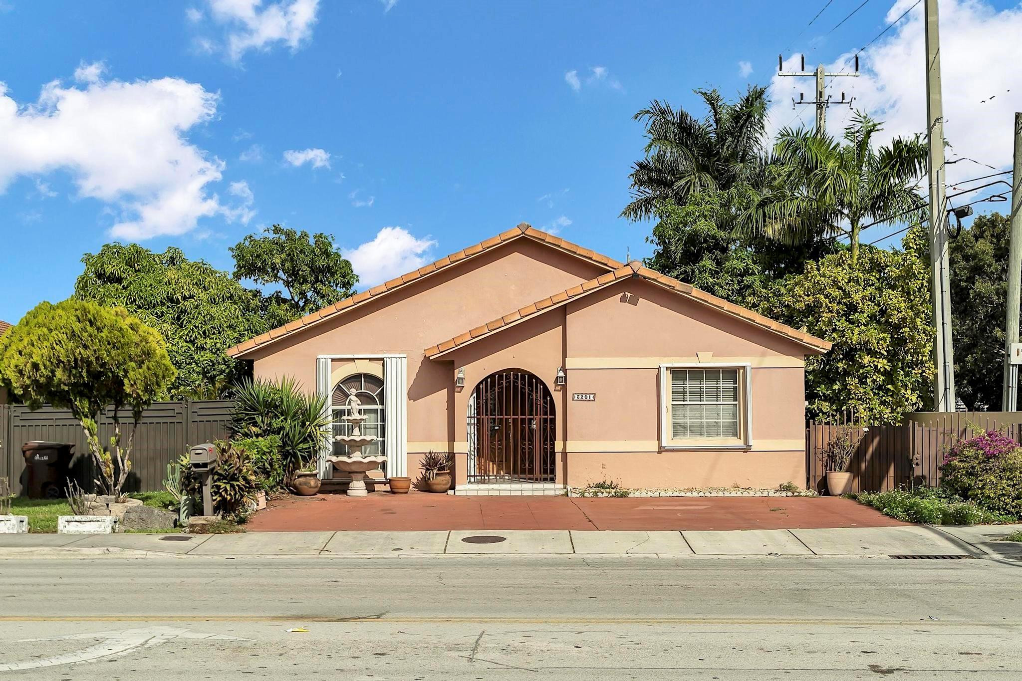 3201 West 76th Street Hialeah, FL 33018 - Photo 1 of 46 a view of a white house with a yard and potted plants