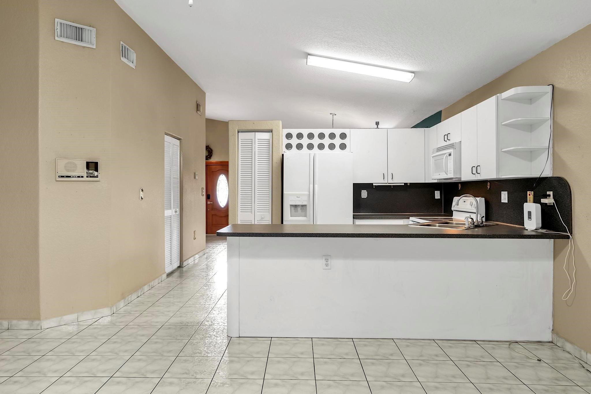 3201 West 76th Street Hialeah, FL 33018 - Photo 22 of 46 a kitchen with granite countertop a stove a sink and a refrigerator