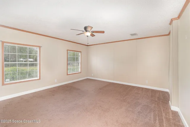 a view of a livingroom with a ceiling fan and window