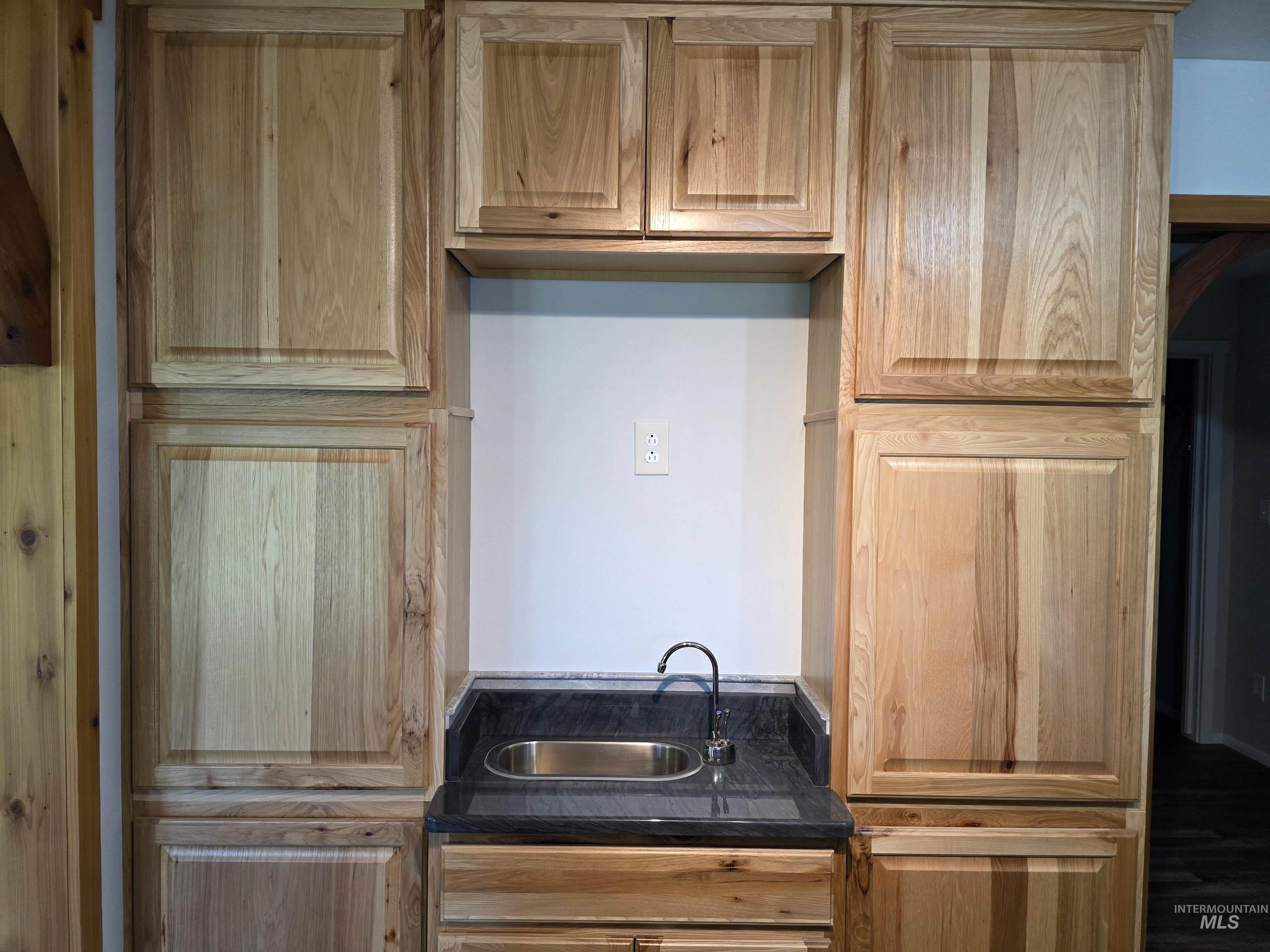 107 Pine Road Kamiah, ID 83536 - Photo 12 of 41 Built-in wood cabinetry with a black stone countertop and undermount stainless steel sink