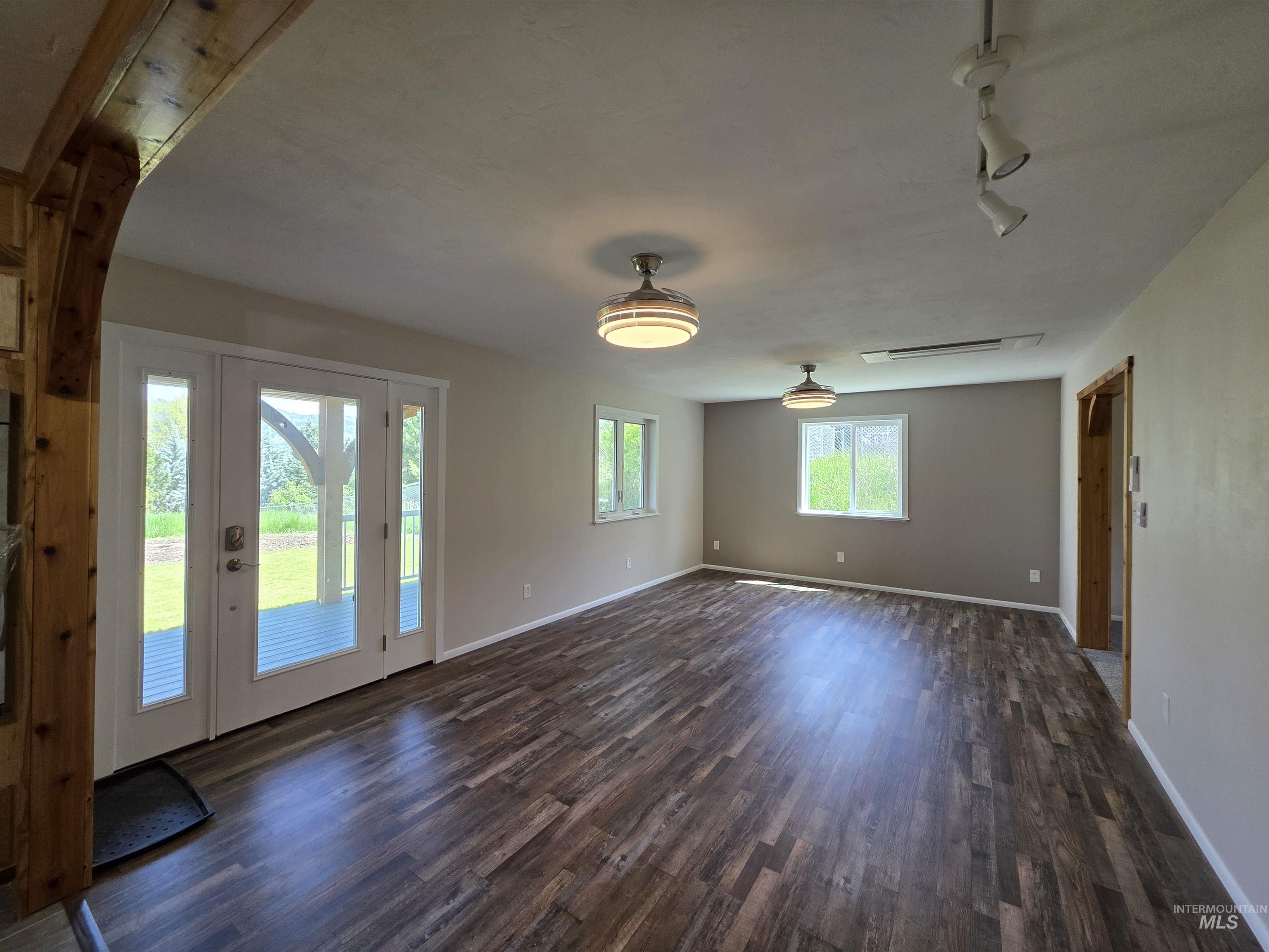 107 Pine Road Kamiah, ID 83536 - Photo 13 of 41 Spacious room featuring wood-finish flooring and two contemporary ceiling fixtures
