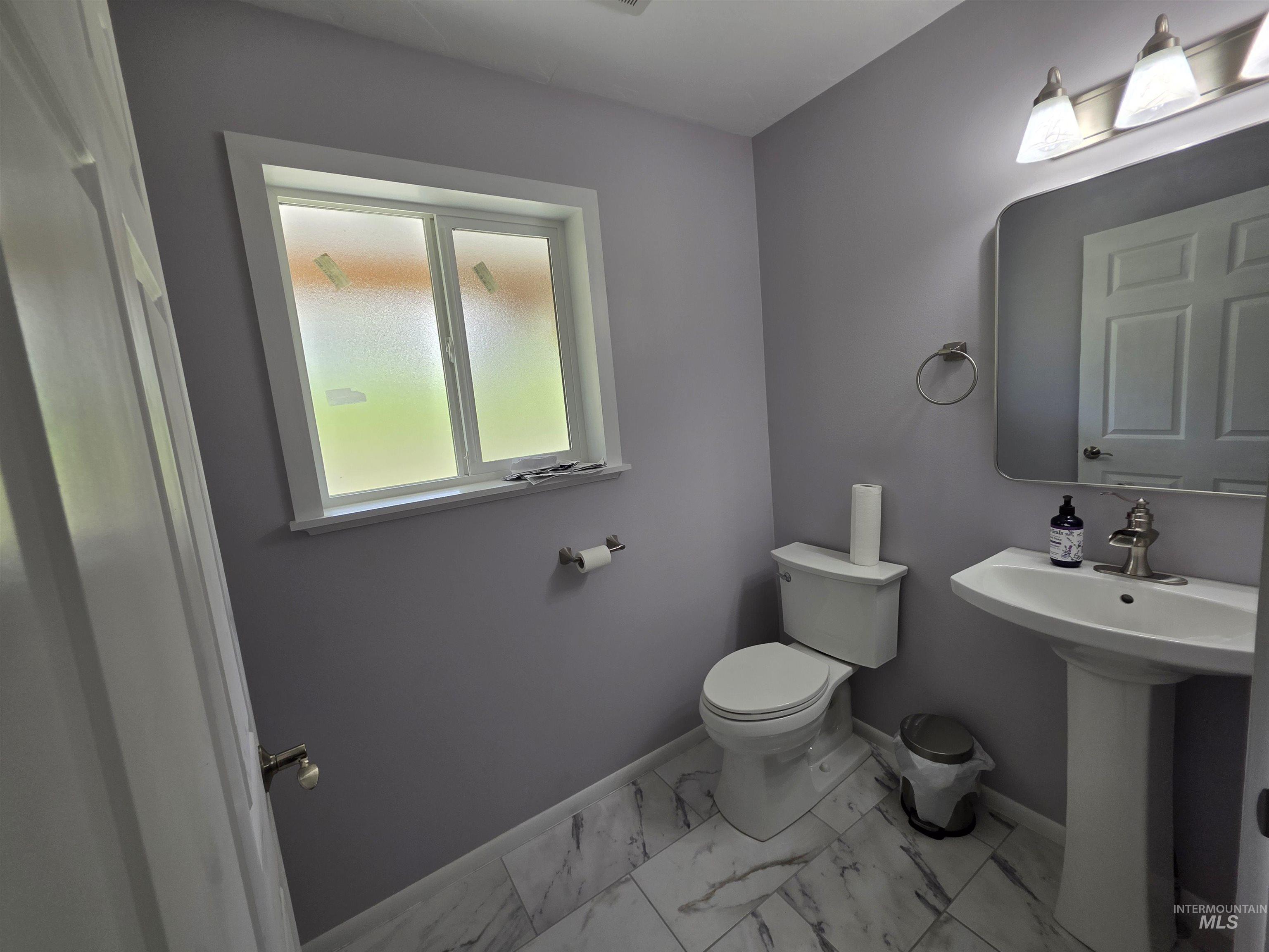 107 Pine Road Kamiah, ID 83536 - Photo 16 of 41 Bathroom featuring a white pedestal sink, white toilet, and gray wall paint