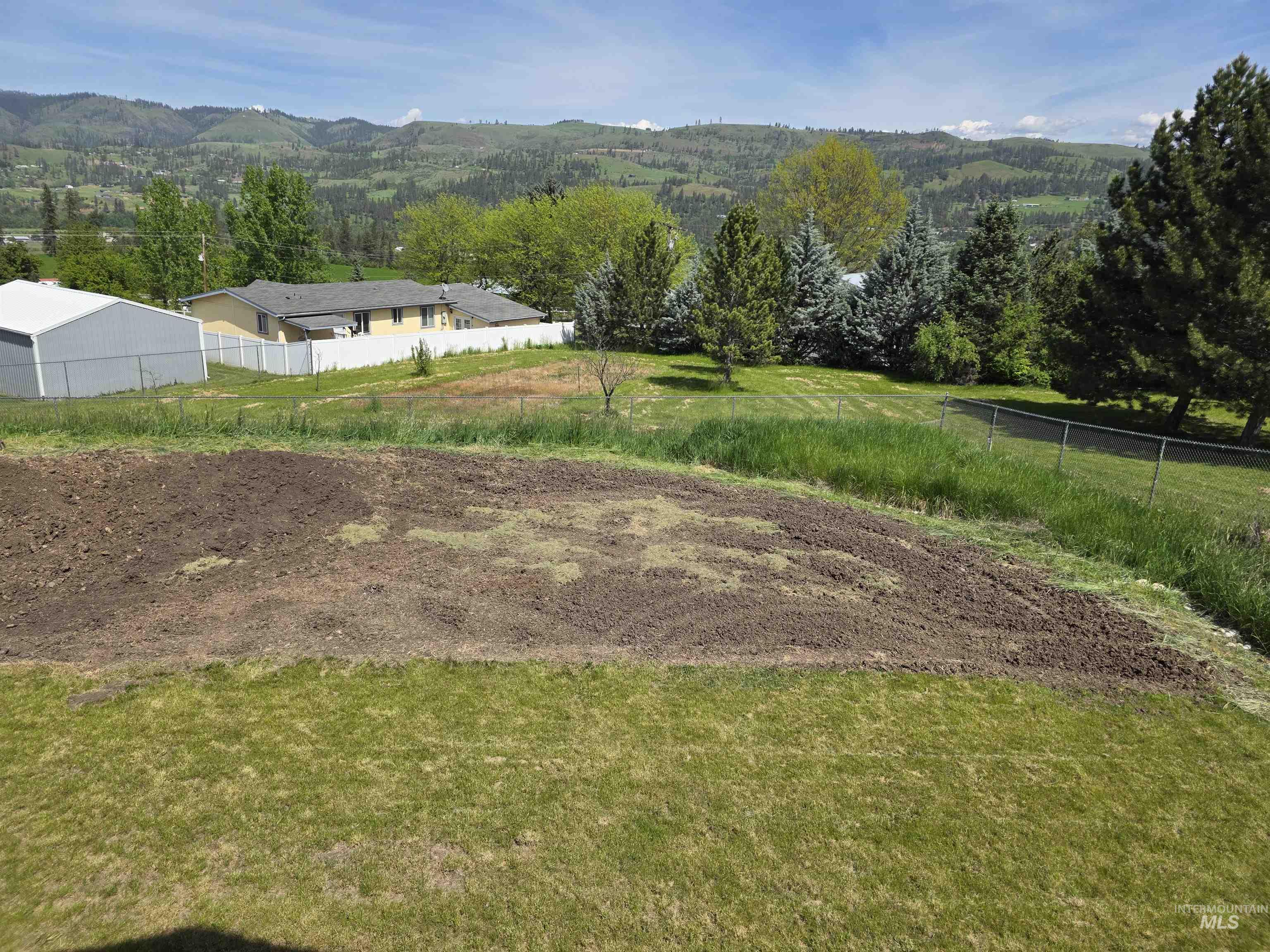 107 Pine Road Kamiah, ID 83536 - Photo 3 of 41 Expansive outdoor space featuring a large tilled garden area, established green lawn, and mature trees