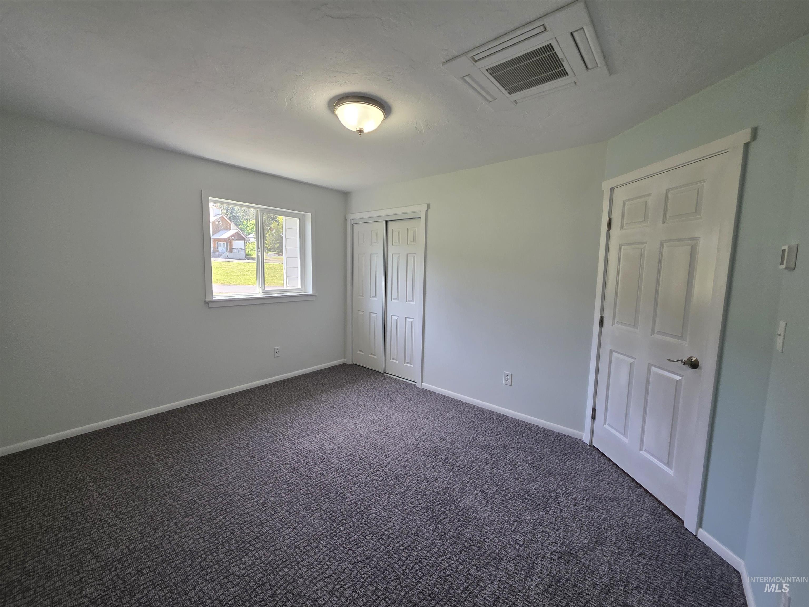 107 Pine Road Kamiah, ID 83536 - Photo 34 of 41 Carpeted room with a ceiling-mounted light fixture, recessed ceiling vent, and a window featuring white trim