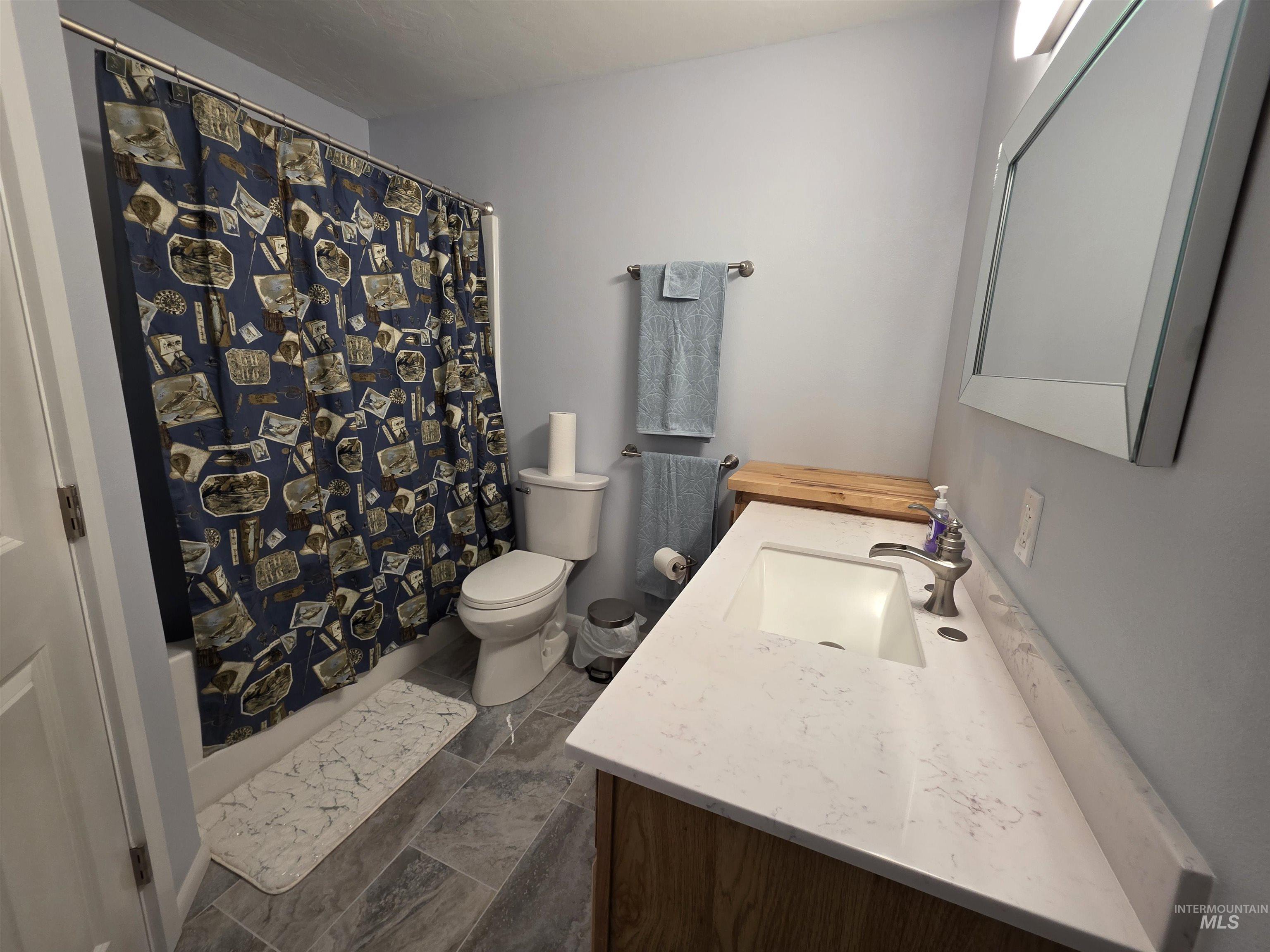 107 Pine Road Kamiah, ID 83536 - Photo 36 of 41 Bathroom featuring a vanity with an integrated white sink, brushed nickel faucet, light-toned countertop, and wood-finish cabinetry