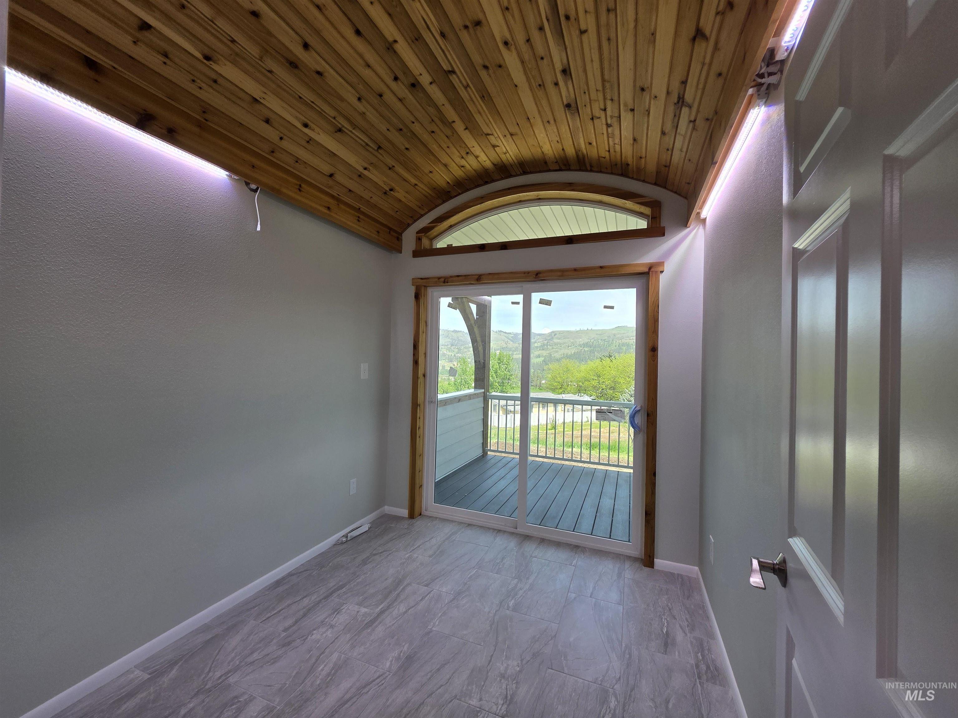 107 Pine Road Kamiah, ID 83536 - Photo 39 of 41 Room featuring a curved wood-finish plank ceiling, tile flooring, and light-toned walls