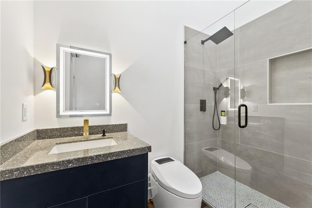 3240 Smithtown Road Suwanee, GA 30024 - Photo 78 of 94 a bathroom with a granite countertop sink toilet and shower