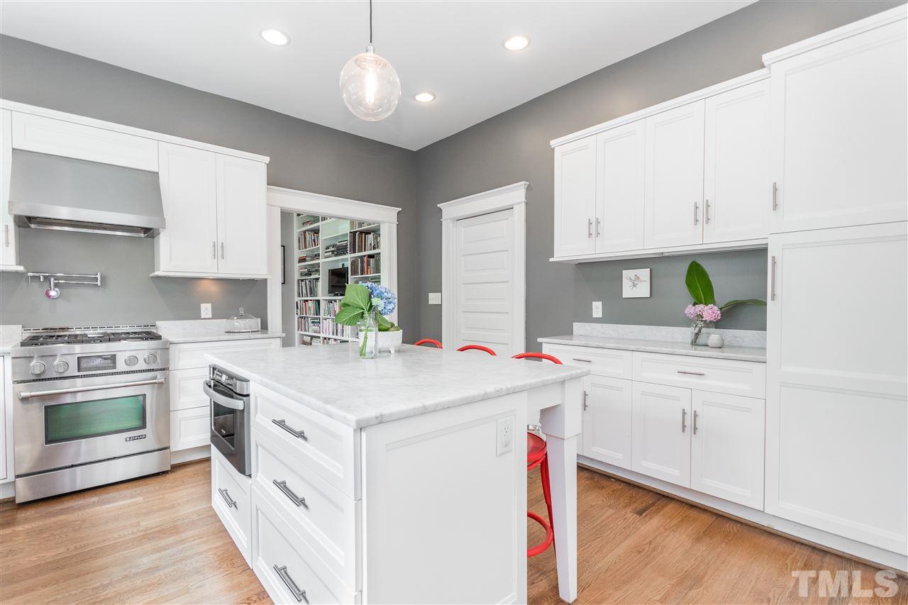 203 Forest Road Raleigh, NC 27605 - Photo 14 of 30 a kitchen with granite countertop a sink stainless steel appliances and white cabinets