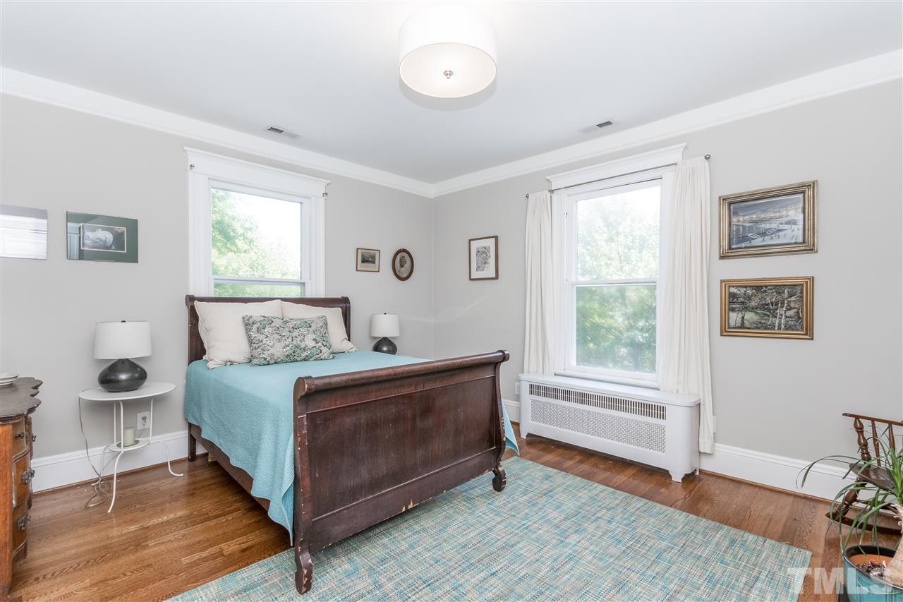 203 Forest Road Raleigh, NC 27605 - Photo 19 of 30 a spacious bedroom with a bed and wooden floor