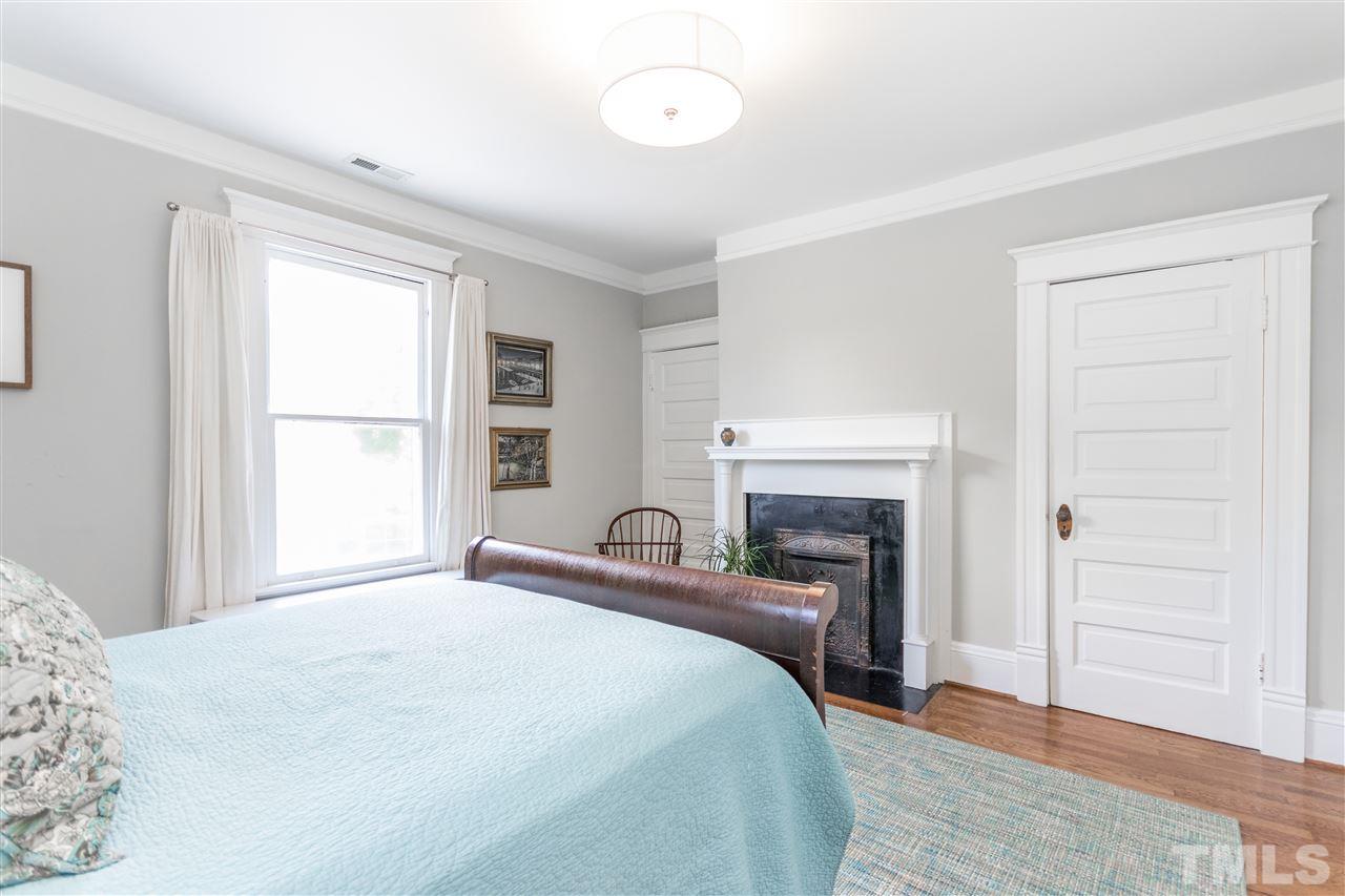 203 Forest Road Raleigh, NC 27605 - Photo 20 of 30 a bedroom with a bed and a fireplace