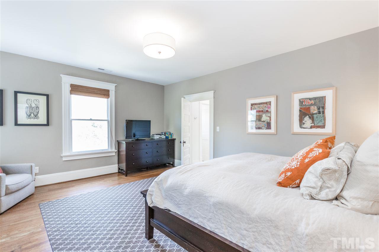 203 Forest Road Raleigh, NC 27605 - Photo 21 of 30 a bedroom with a bed and wooden floor