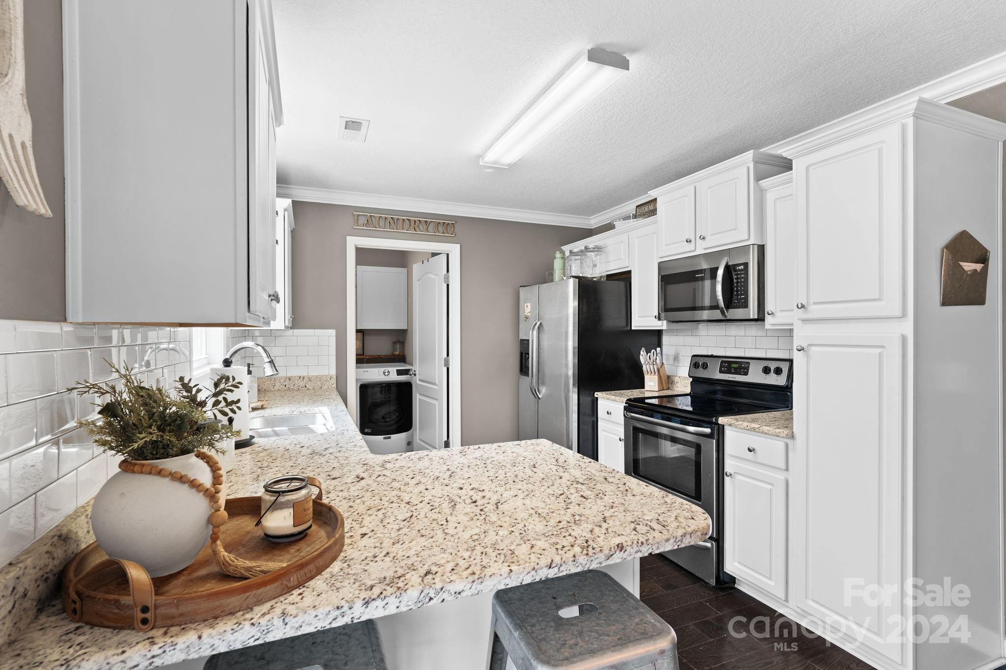 451 Pamela Road York, SC 29745 - Photo 8 of 26 a kitchen with kitchen island granite countertop a sink stainless steel appliances and white cabinets