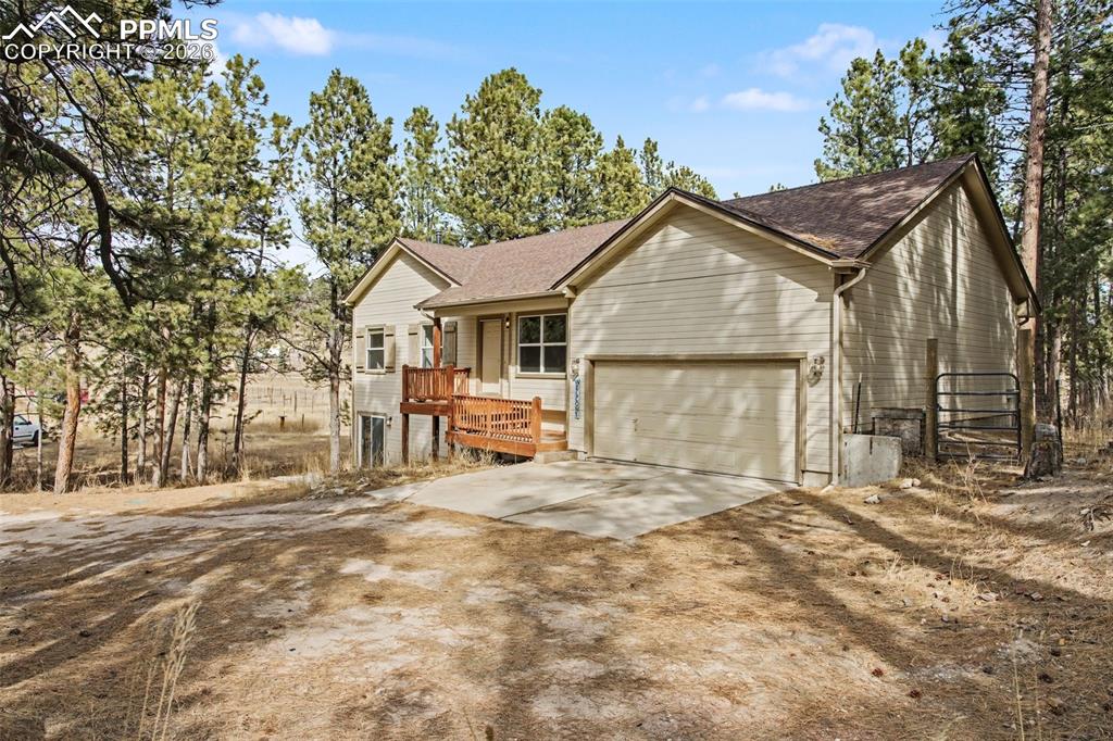 4944 Antelope Trail Elbert, CO 80106 - Photo 2 of 49 Ranch-style home with concrete driveway, a garage, a shingled roof, and a wooden deck
